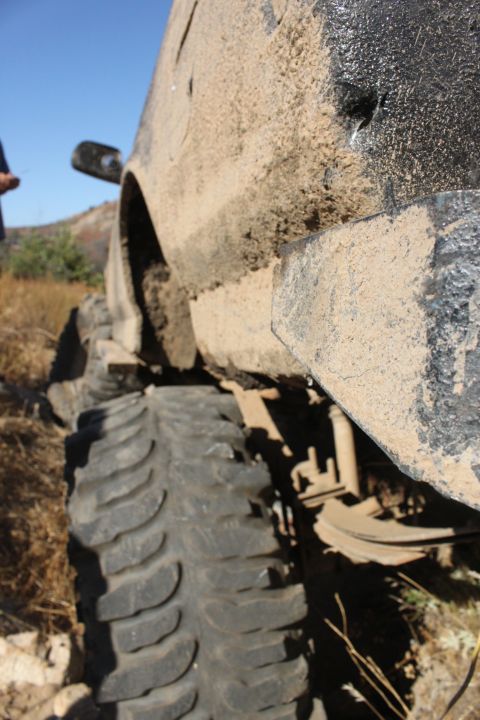 1992 Ford Bronco - Off-road vehicle tire and fender covered in mud, with a watermark visible.