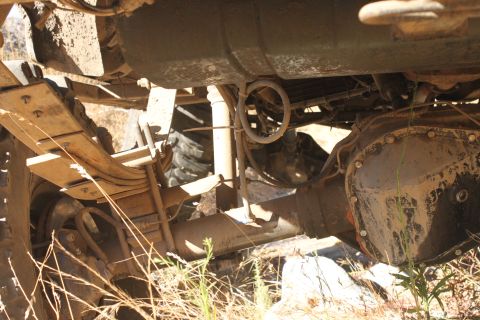 1992 Ford Bronco - A close-up view of a vehicle's undercarriage reveals its suspension and drivetrain components.