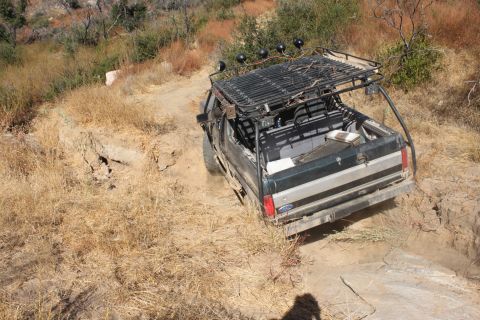 1992 Ford Bronco - Modified 1992 Ford Bronco navigates a challenging off-road trail with steep inclines.
