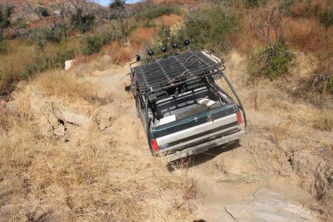 1992 Ford Bronco - A modified Ford truck navigates a rough, dry, off-road trail.