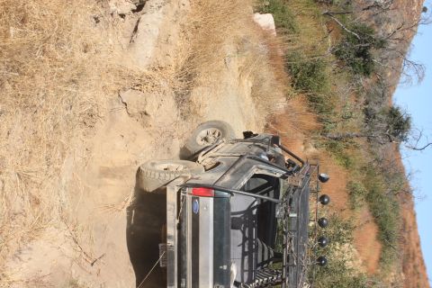1992 Ford Bronco - Off-road Bronco overturned on a steep, dry, dirt embankment.
