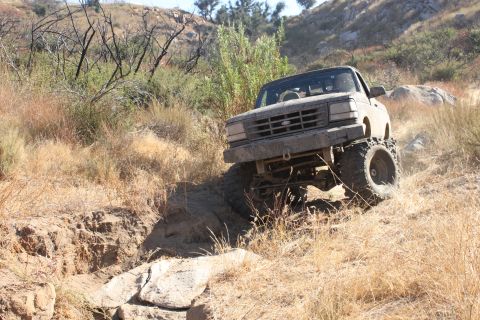 1992 Ford Bronco - A lifted 1992 Ford Bronco navigates a challenging off-road trail.