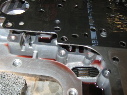2001 Ford Expedition - Close-up of a transmission valve body, showing internal components and fluid.