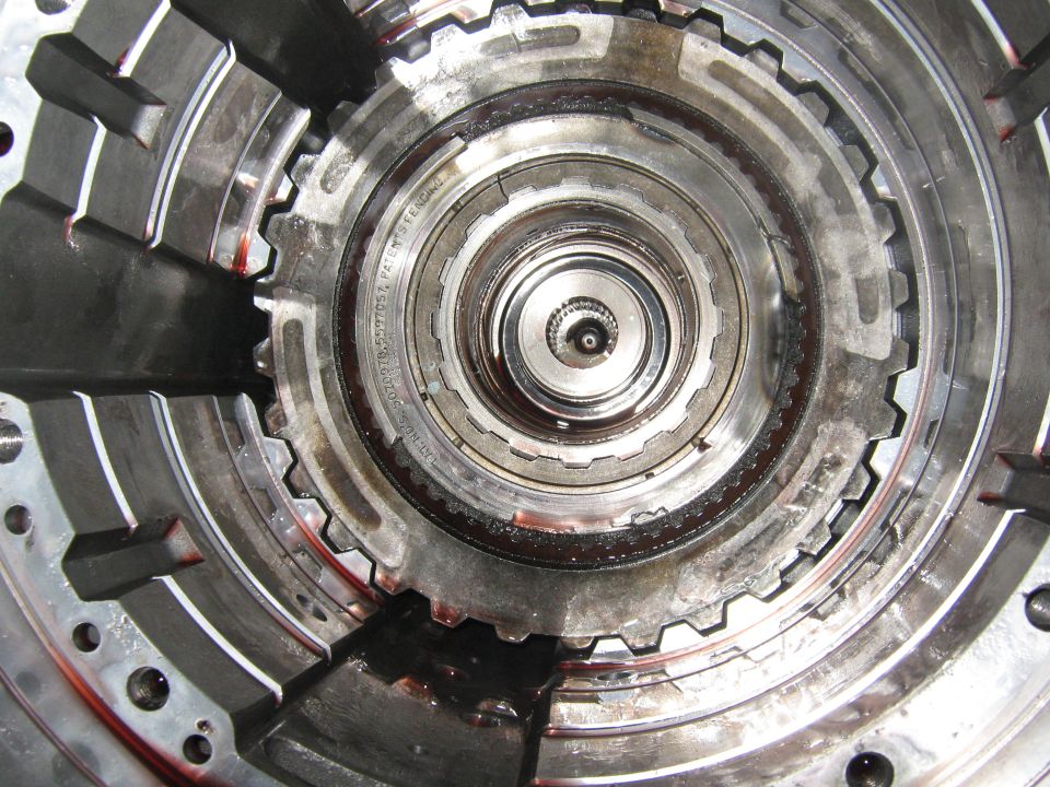 Close-up of internal transmission gears and clutch pack with some fluid visible