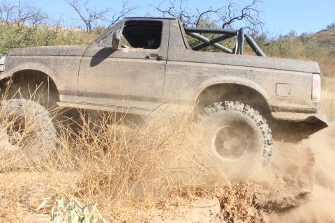1992 Ford Bronco - This 1992 Ford Bronco navigates a dusty trail with aggressive off-road tires.