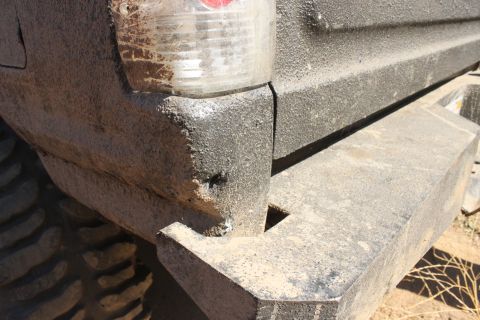 1992 Ford Bronco - Close-up of the rear bumper and taillight of a heavily soiled SUV.