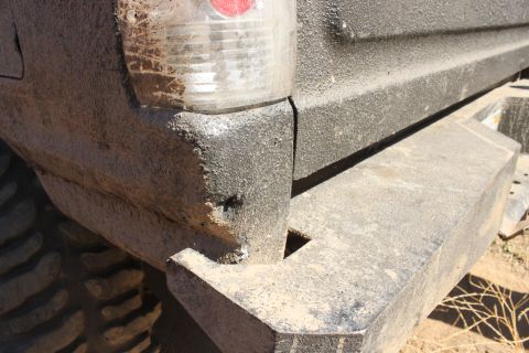 1992 Ford Bronco - Close-up of the dirty rear corner of an off-road vehicle, showing the bumper and taillight.