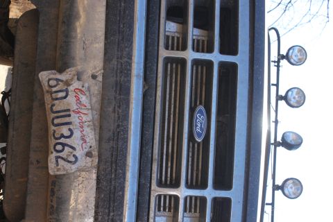 1992 Ford Bronco - A close-up of a 1992 Ford Bronco's front grille, a California license plate and auxiliary spotlights.