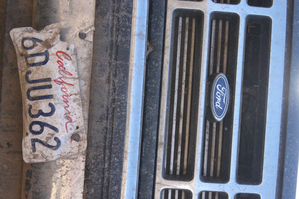 Dirty California license plate 6DJU362 attached to a weathered Ford grille