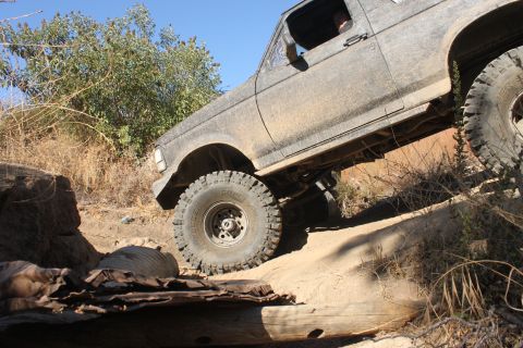 1992 Ford Bronco - 1992 Ford Bronco navigating a challenging off-road obstacle.