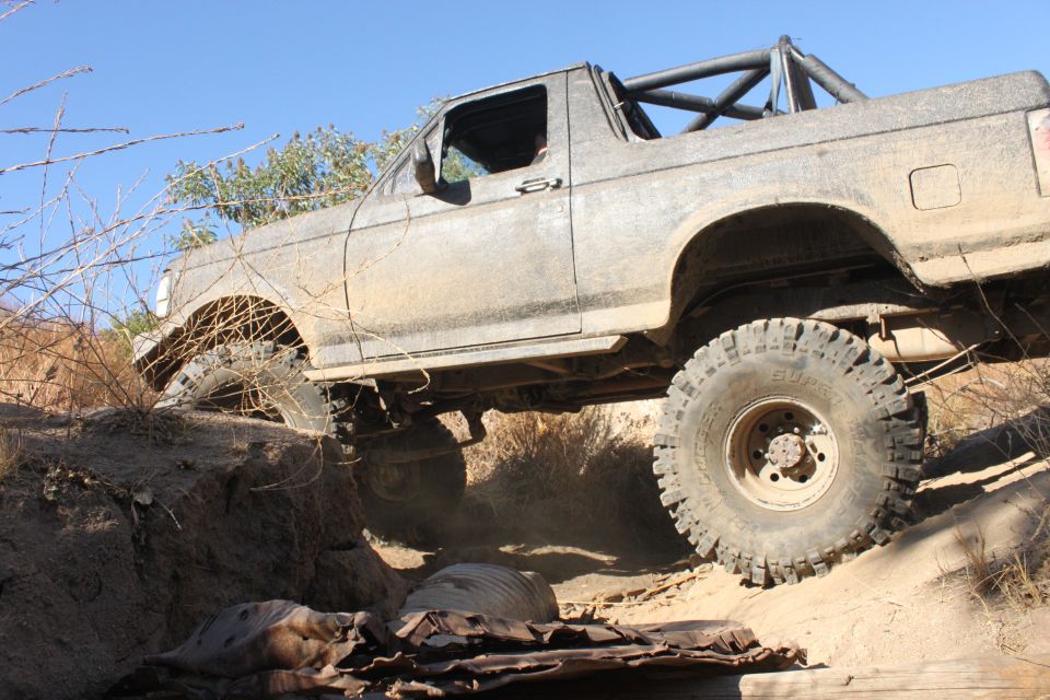 1992 Ford Bronco climbing over rough terrain with large off-road tires