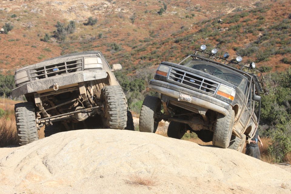 Two 1992 Ford Broncos climbing a rocky hill off-road