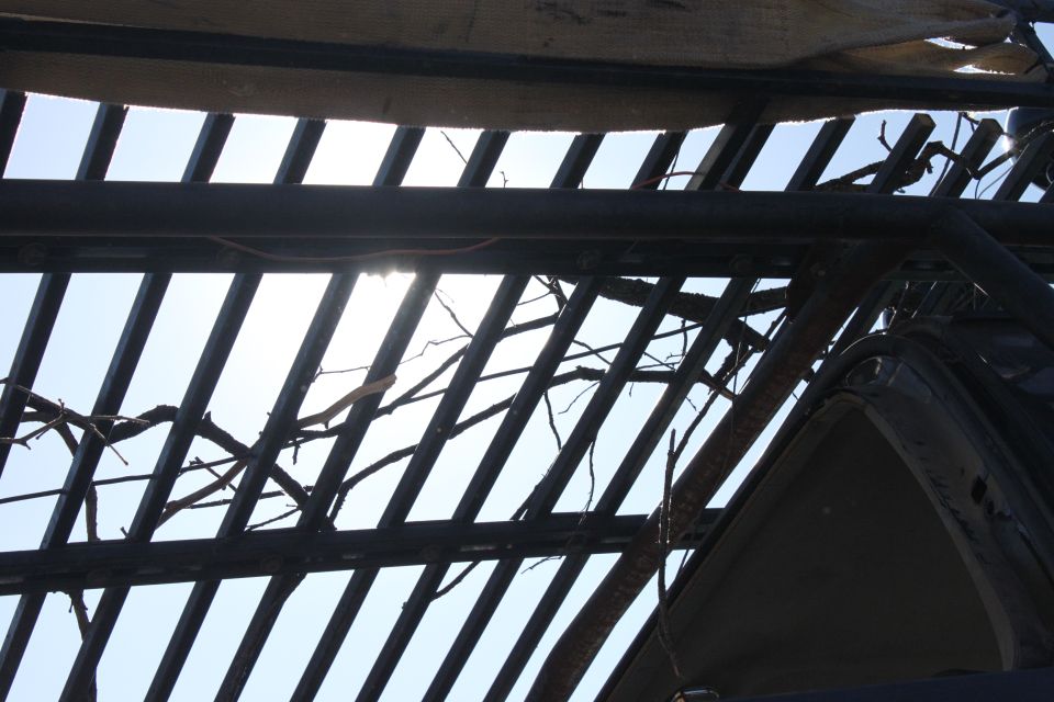 View through damaged roof bars and branches, showing sky. Supermotors.net logo visible