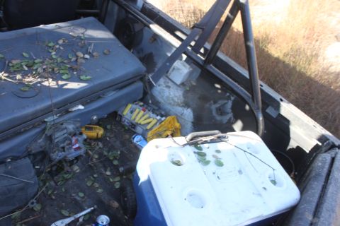 1992 Ford Bronco - The interior of a 1992 Ford Bronco shows a cooler, tools, and debris on the floor.