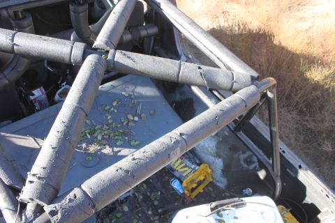 1992 Ford Bronco - The interior of a vehicle shows a prominent roll cage and scattered debris on the floor.