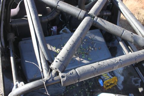 1992 Ford Bronco - Roll cage structure visible inside a vehicle, with a cooler and debris on the floor.