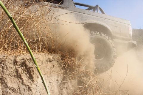 1992 Ford Bronco - This 1992 Ford Bronco navigates a dusty, off-road trail, its rear tire kicking up a cloud of dirt.