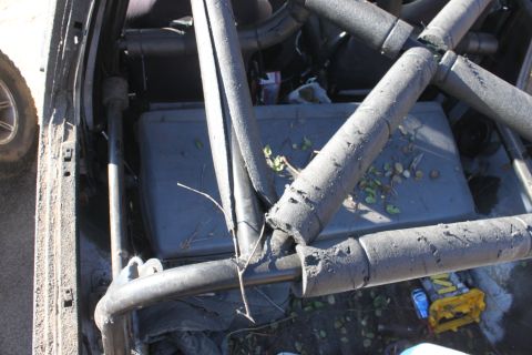 1992 Ford Bronco - The interior of a vehicle is shown with a prominent roll cage structure and a storage bin in the back.