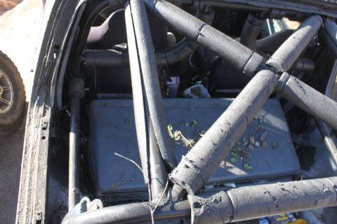 1992 Ford Bronco - The interior of a vehicle shows a roll cage and debris, with another vehicle's tire visible outside.