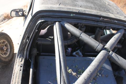 1992 Ford Bronco - Modified vehicle interior with a roll cage, seen from above. A tire is visible to the left.