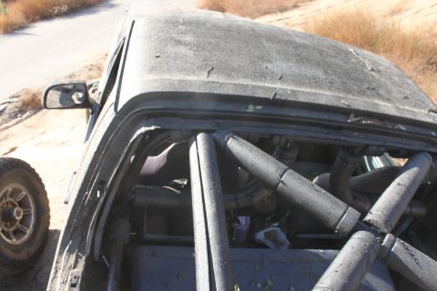 Dark gray 1992 Ford Bronco interior with roll cage, dusty exterior, side view