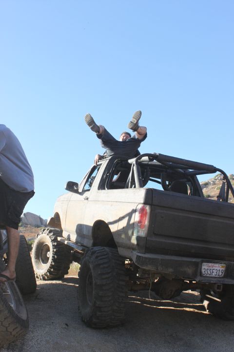 Man on roof of lifted off-road SUV with large tires