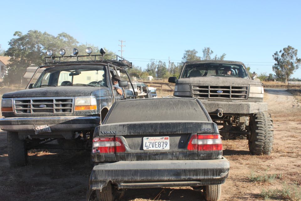1992 Ford Bronco with roof rack and lights, front view, covered in dust