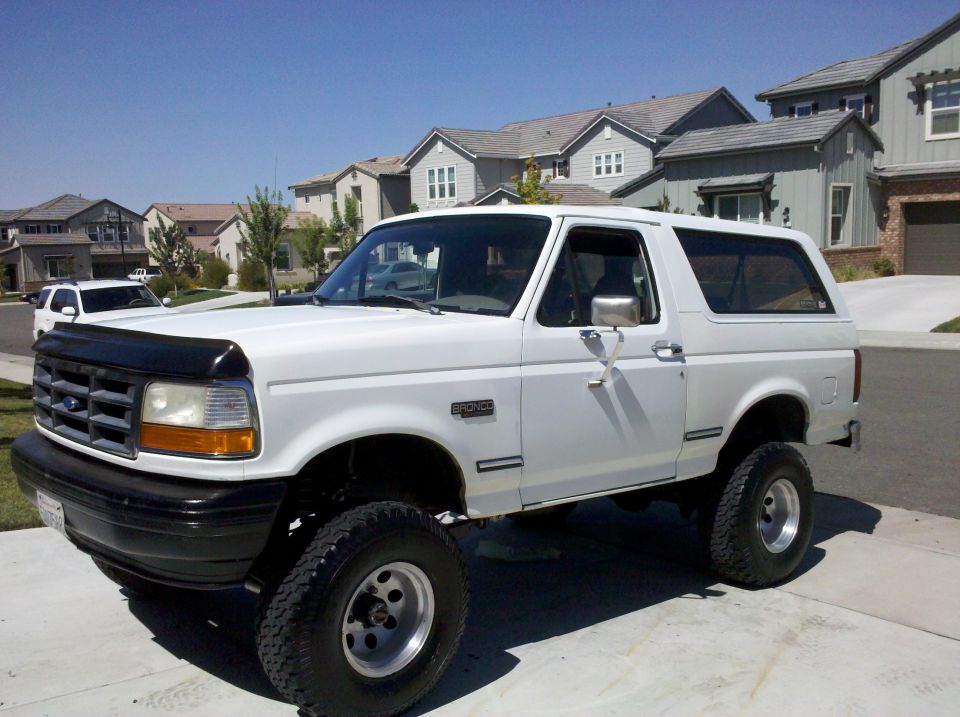 White lifted Ford Bronco SUV on driveway, front-left 3/4 view