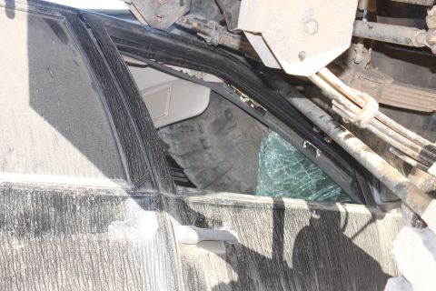 Interior of a crushed vehicle with shattered window and sun visor