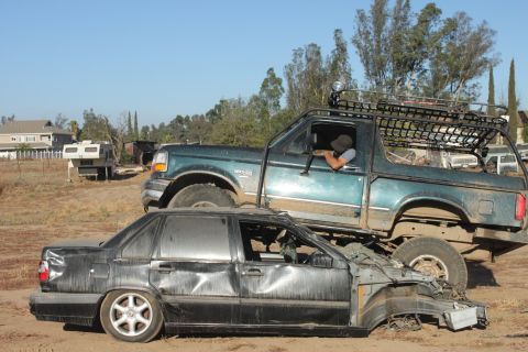 Green 1992 Ford Bronco on top of a severely damaged black sedan