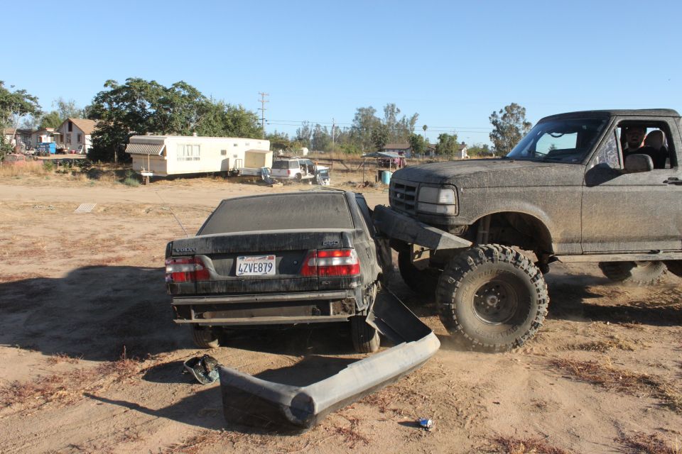 1992 Ford F-Series truck with large tires has crashed into a damaged Volvo sedan