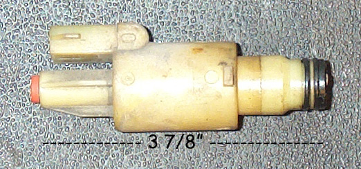 Tan transmission solenoid measured at 3 7/8 inches against textured gray background