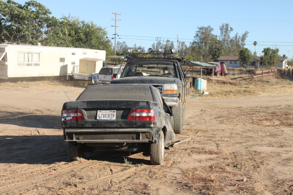 Black sedan with license plate 4ZVE879 being towed by a pickup truck