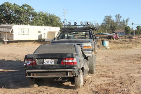 Black sedan with license plate 4ZVE879 being towed by a pickup truck
