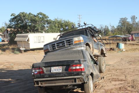 1992 Ford Bronco front grille and roof rack, on top of a black Volvo sedan