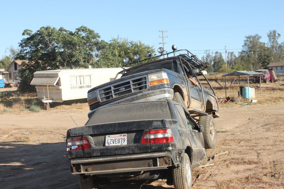 1992 Ford Bronco with roof rack on top of a black Volvo sedan, license plate 4ZVE879