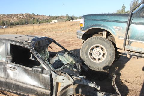 Green 1992 Ford Bronco on wrecked car