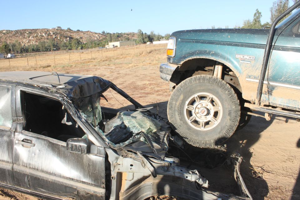 Green 1992 Ford Bronco on wrecked car