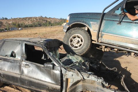 1992 Ford Bronco on top of a crushed car