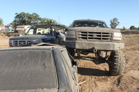 1992 Ford truck front view, covered in mud, with another truck behind it