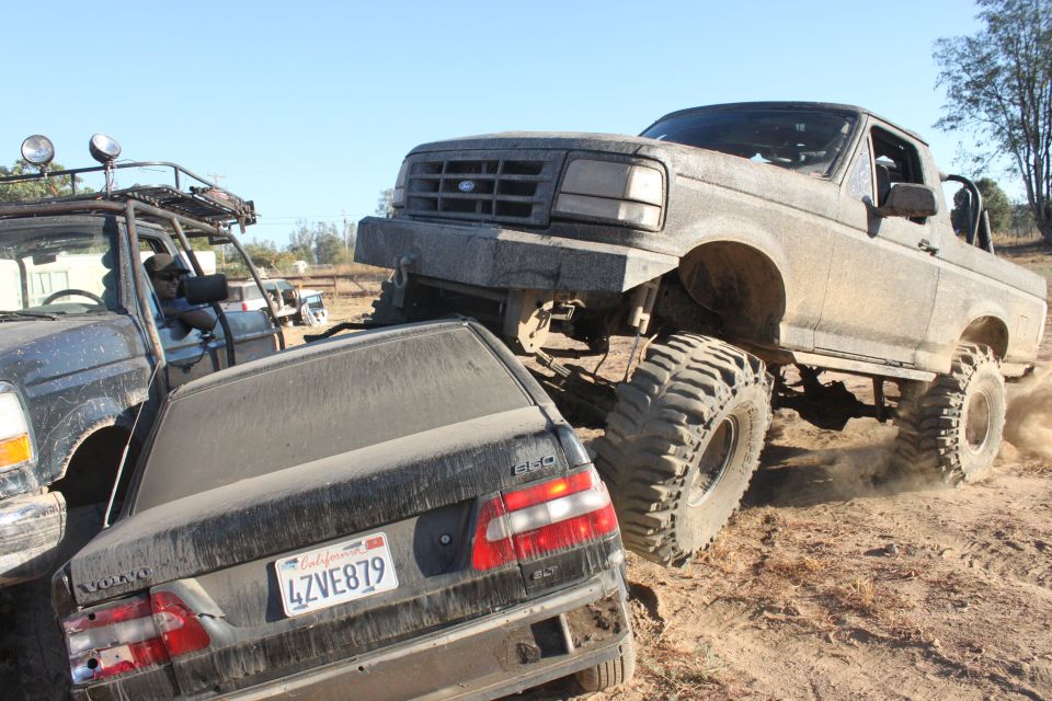 1992 Ford Bronco crushing a Volvo sedan on a dirt trail