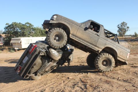 Muddy off-road truck on top of a flipped car