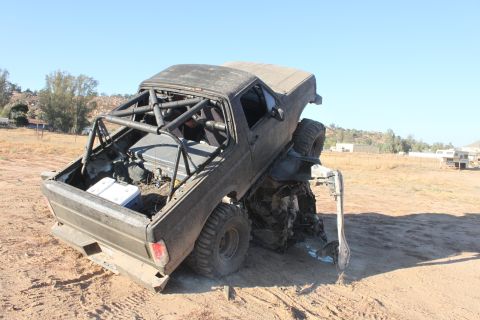 Modified off-road truck with roll cage, stuck in dirt