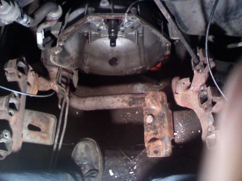 1990 Ford Bronco - Close-up of the underside of a vehicle, showing the transmission and exhaust system components.