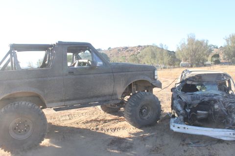 1992 Ford Bronco side view, towing a crushed car