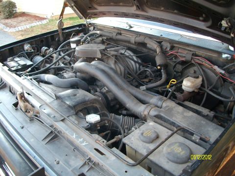 1990 Ford Bronco - Engine bay of a 1990 Ford Bronco, showing the motor and surrounding components.