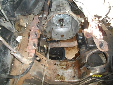 1990 Ford Bronco - Underside view of a vehicle's transmission and exhaust system, showing significant rust and wear.