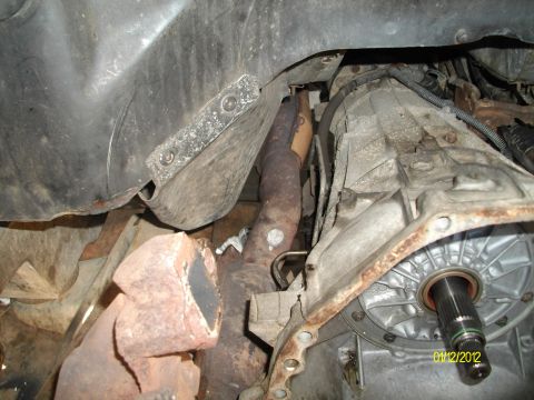 1990 Ford Bronco - Close-up view of a vehicle's exhaust manifold and transmission components.
