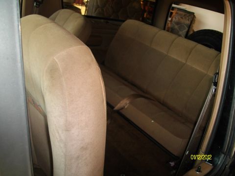1990 Ford Bronco - Interior view of a vehicle's tan cloth seats and trim.