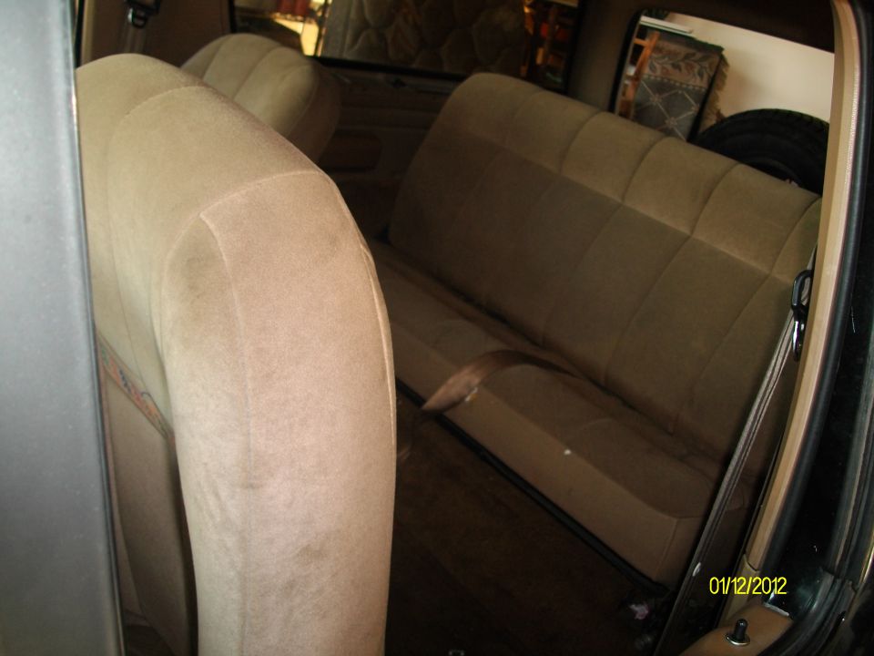 Tan cloth seats and interior of a vehicle, viewed from the side